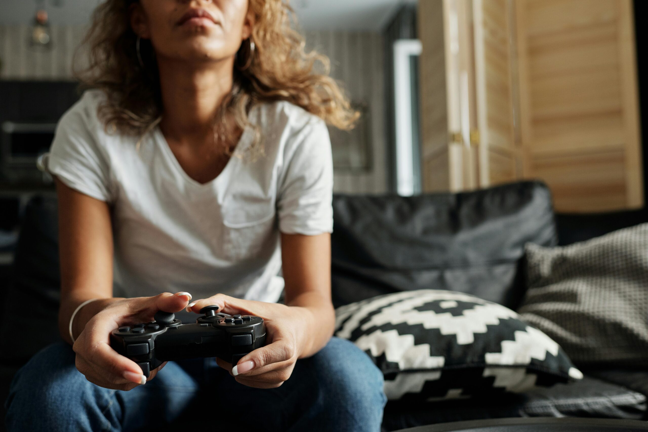 A woman playing video game with her PlayStation controller