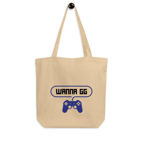 A beige tote bag on which is written "wanna gg" in black with a blue PlayStation controller