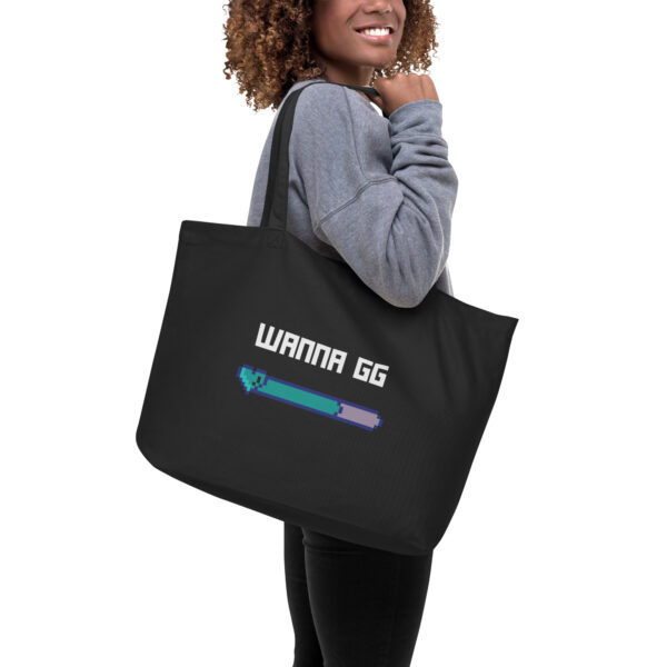 A black tote bag on which is written "wanna gg" in white with a green and blue lifebar underneath