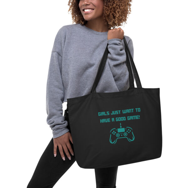 A black tote bag on which is written "girls just want to have a good game!" in green with a green and PlayStation controller underneath