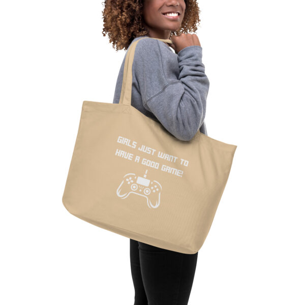 A beige tote bag on which is written "girls just want to have a good game!" in white with a white PlayStation controller underneath