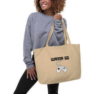 A beige tote bag on which is written "wanna gg" in black with a white PlayStation controller underneath