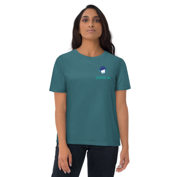 A woman posing head-on wearing a green/blue tshirt on which is written "wanna gg" underneath our website logo