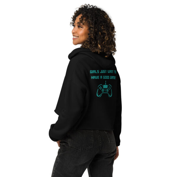 A woman posing from behind wearing a black sweatshirt on which is written "girls just want to have a good game!" in green with a green PlayStation controller underneath