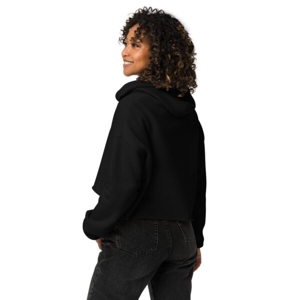 A woman posing from behind wearing a black sweatshirt with no pattern on the back