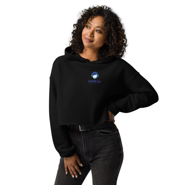 A woman poses head-on wearing a black sweatshirt on which it says "wanna gg" in blue underneath our logo website