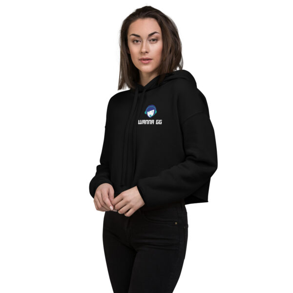 A woman poses head-on wearing a black sweatshirt on which it says "wanna gg" in white underneath our logo website