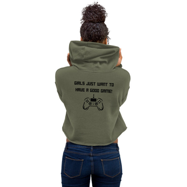 A woman posing from behind wearing a khaki-coloured sweatshirt on which is written "girls just want to have a good game!" in black with a black PlayStation controller underneath