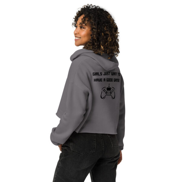 A woman posing from behind wearing a grey sweatshirt on which is written "girls just want to have a good game!" in black with a black PlayStation controller underneath