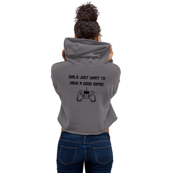 A woman posing from behind wearing a grey sweatshirt on which is written "girls just want to have a good game!" in black with a black PlayStation controller underneath