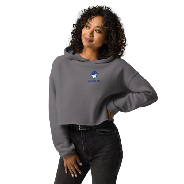 A woman poses head-on wearing a grey sweatshirt on which it says "wanna gg" in blue underneath our logo website