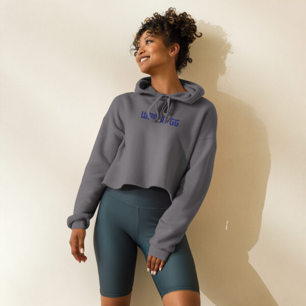 A woman poses head-on wearing a grey sweatshirt and it says "wanna gg" in blue in the middle