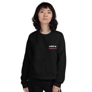 A woman poses head-on wearing a black sweater and it says "wanna gg" in white with 5 pink hearts underneath