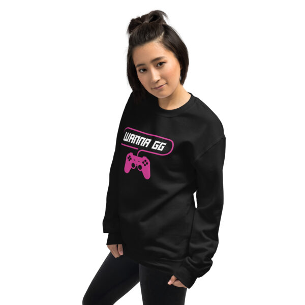 A woman poses sideway wearing a black sweater and it says "wanna gg" in white with a pink PlayStation controller