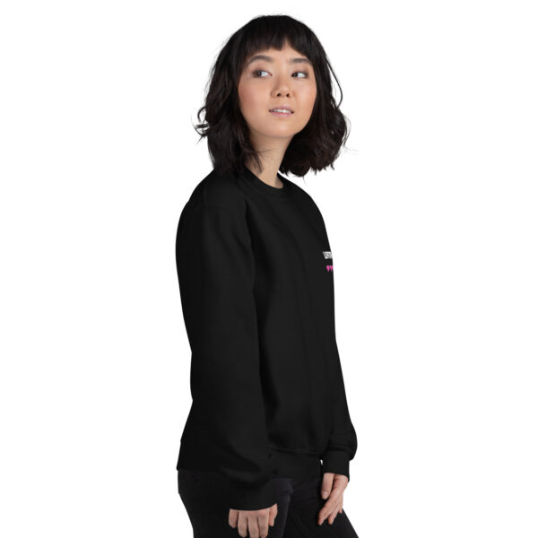 A woman poses sideways wearing a black sweater and it says "wanna gg" in white with 5 pink hearts underneath